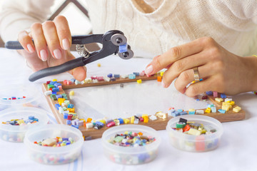 Woman decorating photo frame with colorful glass mosaic