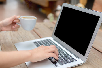 Fototapeta premium Closeup of business woman hand typing on laptop keyboard and cof
