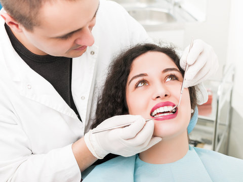 Young woman having teeth examined at dental office