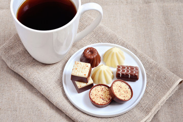 Various chocolate candies and a cp of coffee