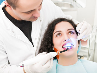 Dentist using dental curing UV lamp