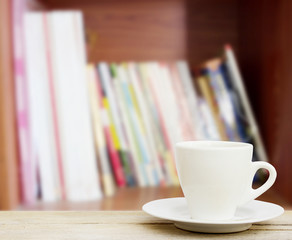 coffee in the cup on old wood table with blur office background