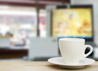 coffee in the cup on old wood table with blur office background