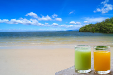 Glass of fruit juice served on the beach