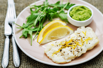 Fototapeta na wymiar cod baked with lemon and spices with arugula and mashed green pe