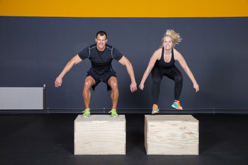 Man and woman jumping on a box - cross fit