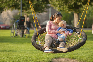 Mutter und Sohn liegen auf einer Schaukel