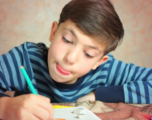 preteen handsome boy drawing with colored pencils and crayons
