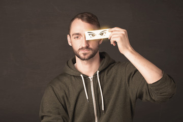 Cool youngster looking with a paper hand drawn eyes