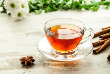 Glass cup of tea on a wooden table.