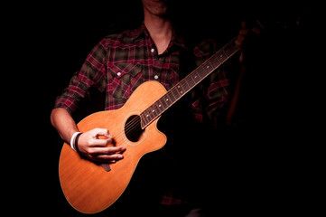 Fototapeta na wymiar Long hair guy playing guitar acoustic