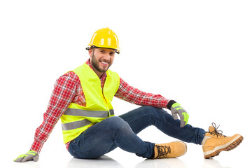 Relaxed construction worker sitting on a floor