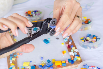 Woman decorating photo frame with colorful mosaic