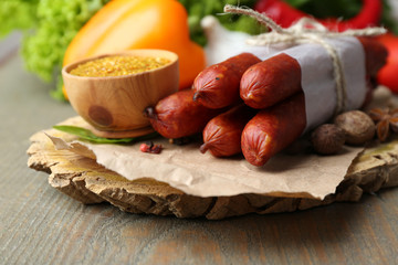 Composition of smoked thin sausages, mustard in bowl and spices
