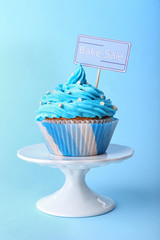 Delicious cupcake with inscription on blue background