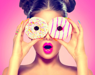 Beauty model girl taking colorful donuts. Dieting concept