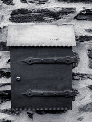 postbox on a wall in black and white