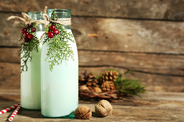 Bottles of fresh milk with natural decor, on wooden background