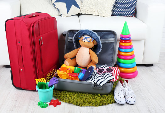 Suitcase packed with clothes and child toys