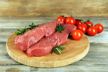 Raw beef steak with rosemary and cherry tomatoes