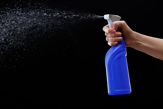 Male Hand Spraying Water On Black Background