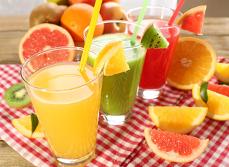 Fresh juices with fruits on wooden table