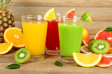 Fresh juices with fruits on wooden table