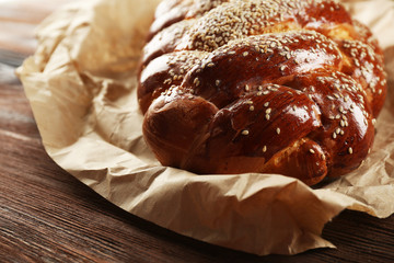 Fresh bun on paper on wooden background
