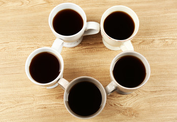 Cups of coffee on wooden table background