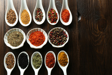Different kinds of spices in bowls and spoons, close-up,