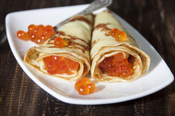 Two pancake in the form of horns with red caviar  .