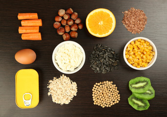 Various food products containing vitamins on wooden background