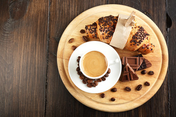 Fresh and tasty croissants with chocolate and cup of coffee