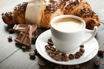 Fresh and tasty croissants with chocolate and cup of coffee