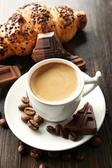Fresh and tasty croissants with chocolate and cup of coffee