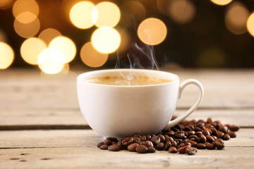 Cup of coffee on table on brown background