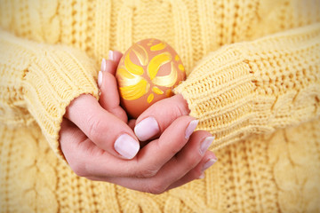 Female hands holding Easter egg, closeup view