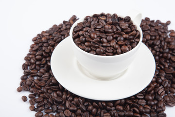 Roasted coffee beans with a cup