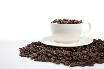 Roasted coffee beans with a cup