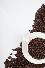 Roasted coffee beans with a cup