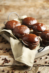 Tasty homemade chocolate muffins on wooden table