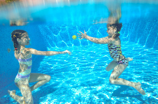 Children swim in pool underwater, girls swimming