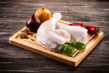 Raw chicken legs on cutting board