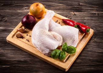 Raw chicken legs on cutting board