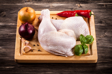 Raw chicken legs on cutting board
