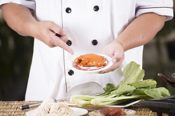 Chef present roasted chicken with noodle ingredient