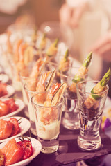 Obraz na płótnie Canvas Glasses with seafood snacks, toned image