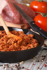 Bolognese sauce in a frying pan close-up vertical