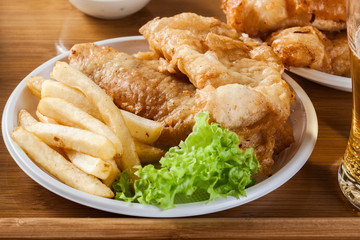 Fish and chips with tartar sauce on a tray