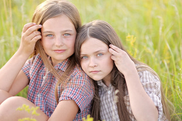 Portrait of two beautiful girlfriends on the nature